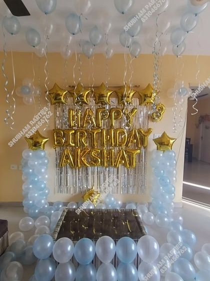 A simple and elegant home birthday setup with light blue and silver balloons.