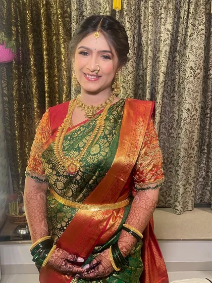 The full traditional look for the puja, complete with a beautiful silk saree and gold jewelry, enhanced by timeless makeup.