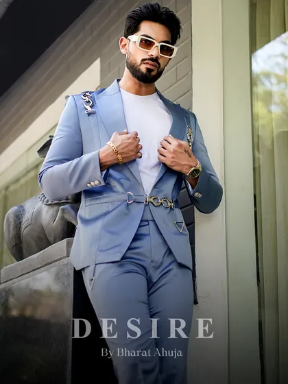 This custom light blue suit is crafted for distinction. The unique silver chain hardware adds a rebellious edge to the otherwise classic and elegant tailoring.