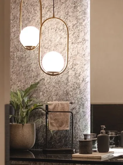 A close-up of the powder room's lighting, where modern brass fixtures contrast beautifully with the textured wallpaper.
