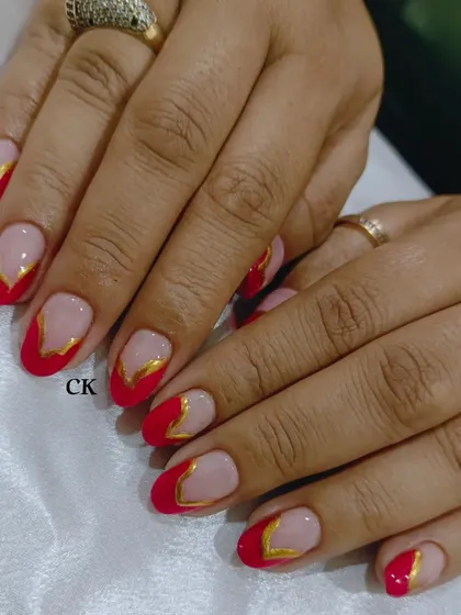 Another view of the red and gold V-shaped French manicure. This is a powerful and glamorous look.