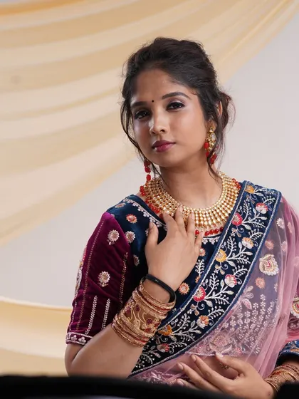A close-up of the navy blue velvet lehenga, showing the detailed embroidery on the blouse and the beautiful traditional jewelry I provide.