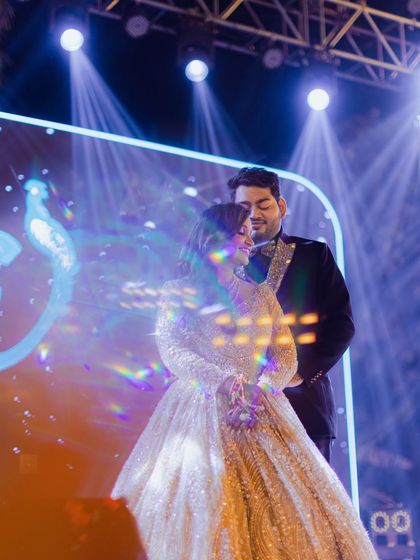 A dreamy portrait of the couple on stage, captured with a creative prism effect that enhances the magical lighting.