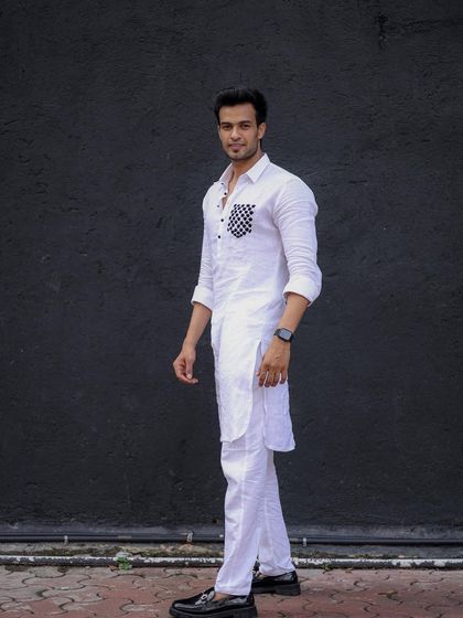 A full-length shot of the white linen kurta with a checkered pocket. Paired with black loafers, it's a perfect smart-casual ethnic look.