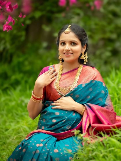 A close-up portrait of the radiant mom-to-be, seated in the grass and surrounded by the beauty of nature.