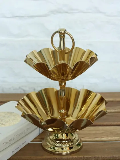 Our two-tiered gold stand with scalloped, flower-shaped bowls. Its intricate design and polished finish make it a luxurious centerpiece for serving sweets and treats.