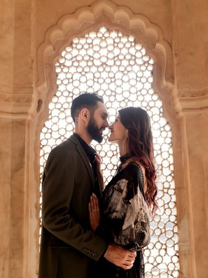 A silhouette of the couple about to embrace, framed perfectly by a traditional palace archway. This is a classic example of our Bollywood-style pre-wedding photography.