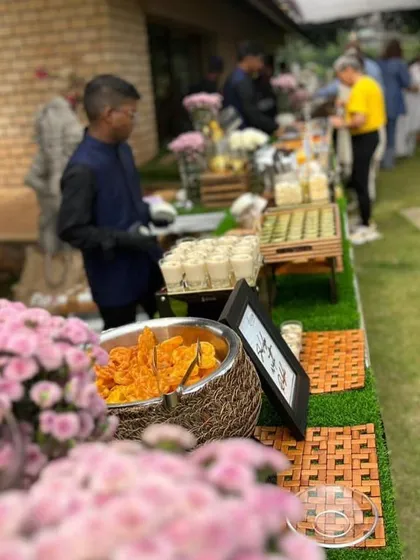 An outdoor buffet setup featuring a mix of hot jalebis and cool thandai shots. I love creating spreads that offer a variety of temperatures, textures, and tastes for guests to explore.