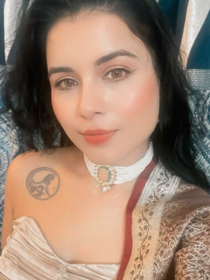 This shot gives a clear view of the client's shoulder tattoo next to the elegant pearl choker, showcasing a beautiful blend of modern personal style and traditional accessories.