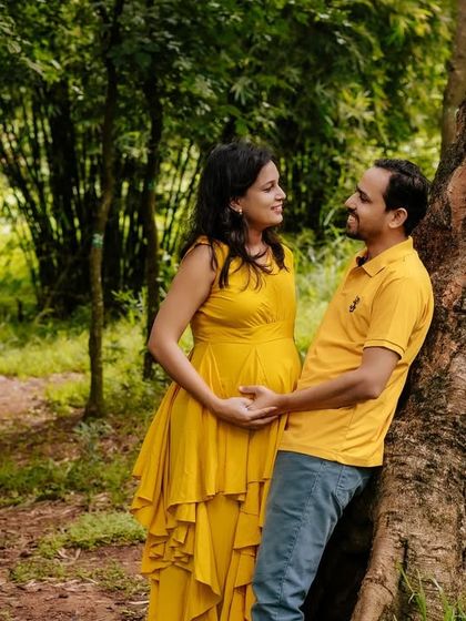 A candid moment of connection between an expecting couple during their outdoor maternity shoot. The natural setting provides a relaxed and intimate atmosphere.