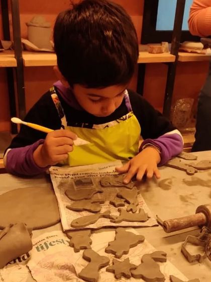 A young boy uses cookie cutters to create fun shapes from a slab of clay. Hand-building is full of playful techniques that kids absolutely love.