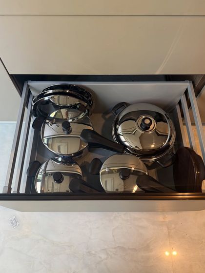 This drawer uses vertical racks to store steel pots and their lids. This method not only saves space but also makes it easy to pull out one pot without disturbing the others.