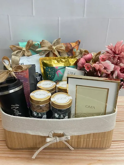 A welcome hamper for the 'Fighter' cast, including a personalized tumbler, a photo frame, and various gourmet snacks.