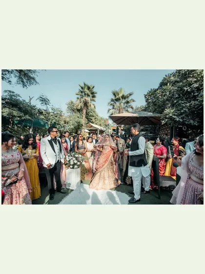 A wide shot of the outdoor wedding ceremony, showing the couple, guests, and the beautiful natural setting.