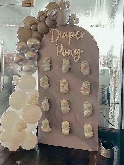 Add some fun to your baby shower with a "Diaper Pong" game station. I create a custom board and decorate it with matching balloons to fit your party's theme.