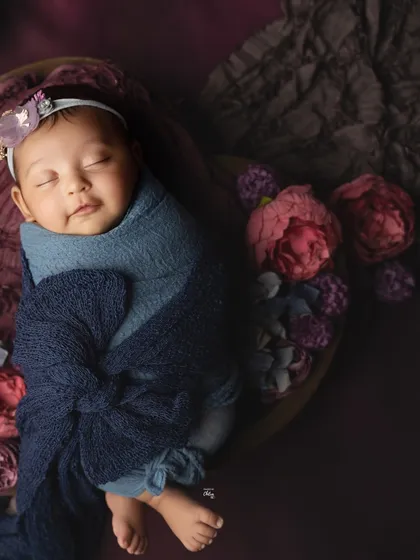A beautiful combination of deep blue and rich purple tones creates a jewel-toned palette for this baby girl's portrait.
