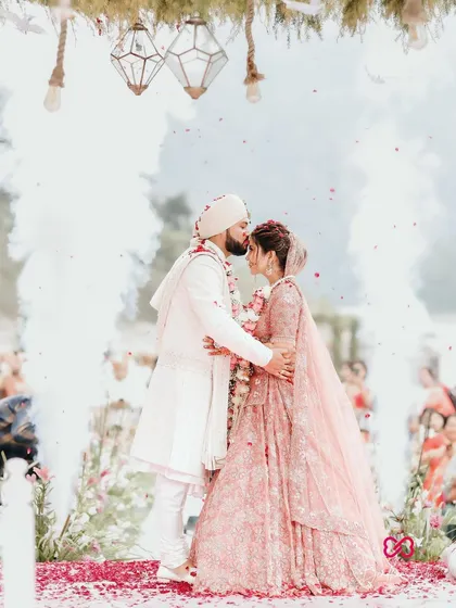 An intimate kiss under a shower of petals. This is the essence of our work, capturing the quiet, powerful connection between two people amidst the grand celebration of their wedding day.