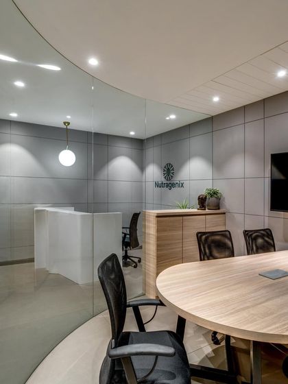 For this office, a curved glass partition separates a small visitor room from the reception. This solution facilitates better circulation and creates a semi-private meeting space without sacrificing the open, modern feel.