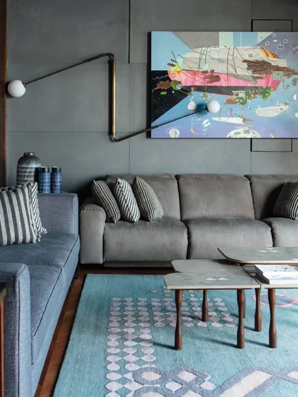 The family lounge in our Kolkata project, featuring a large abstract painting by Thukral and Tagra. The space combines comfortable seating with bold art and a 'Flutter' light fixture by Paul Matter.