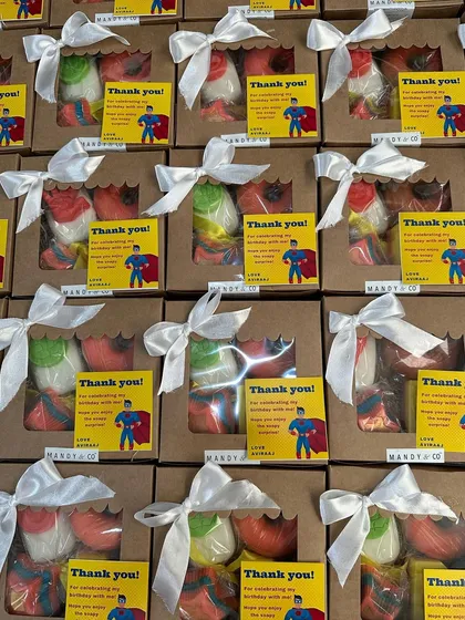 A superhero-themed return gift box with custom 'Thank You' cards, ready for a 5-year-old's birthday party.