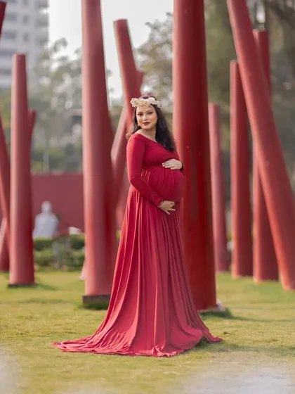 A striking solo portrait in a red gown, set against a modern backdrop of red pillars.