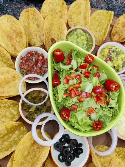 Get the party started with our vibrant Taco Platter. It comes with everything you need: crispy taco shells, fresh lettuce, salsa, guacamole, mango salsa, refried beans, and assorted toppings for a build-your-own taco experience.