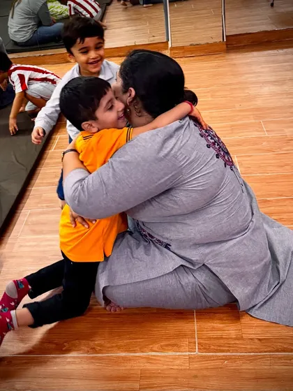 The smiles say it all. A child's happy embrace shows the joyful and positive atmosphere that makes kids excited to come to our classes.
