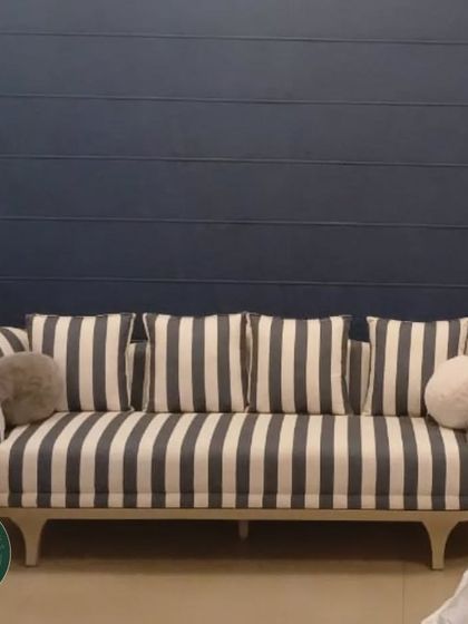 A closer look at our striped sofa, showcasing the fabric's texture and the playful, round throw pillows. We focus on every detail to ensure our custom furniture is both visually appealing and comfortable.