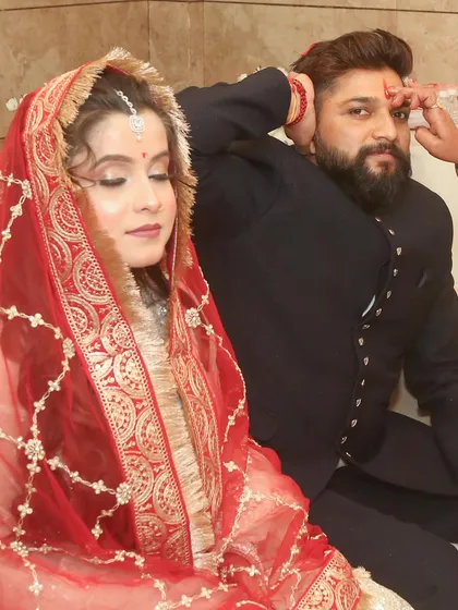 A ritual during the engagement ceremony, with the bride's eyes closed in a moment of prayer.