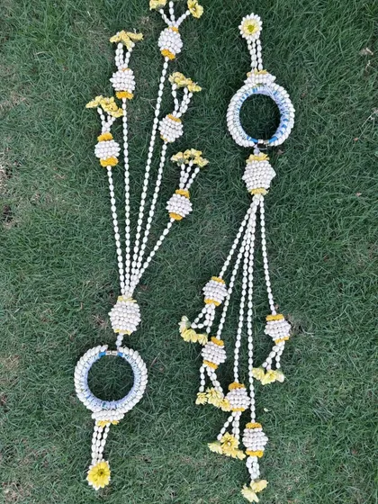 A pair of handcrafted floral hathphool with kalire. The design uses mogra buds and yellow flowers, perfect for matching with a yellow Haldi outfit.