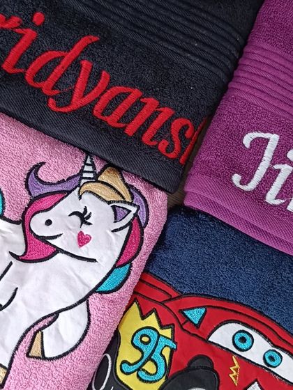 Custom embroidered towels for kids. This set includes unicorn and 'Cars' themed towels with personalized names like Hridyansh and Jinisha.