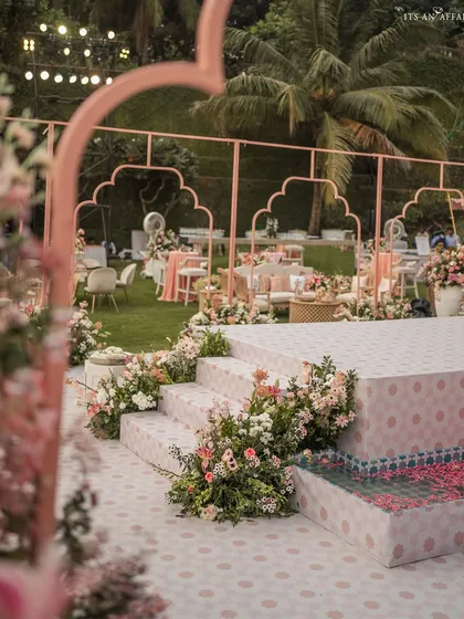 The steps leading up to the performance stage, lined with flowers. The custom-printed tiles and blush-pink arches create a beautiful frame for the evening's entertainment.