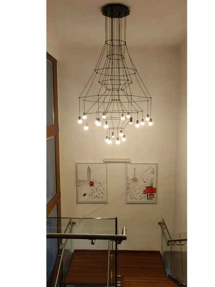 This hallway combines a wooden bridge, glass railings, and a striking marble feature wall. The design emphasizes clean lines and the beautiful contrast between different natural materials.