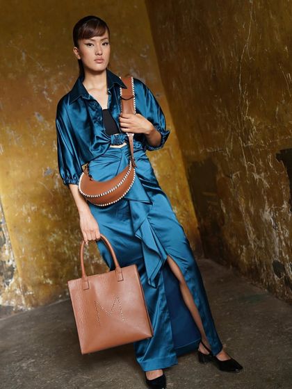 A showcase of two of our favorite brown leather bags: the Studded M tote and the Selena Studded crossbody. Both are designed to be timeless and functional.