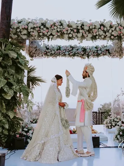 A wide shot of the Varmala ceremony under a stunning floral mandap. The setting is just as important as the ritual itself, and I ensure it's always breathtaking.