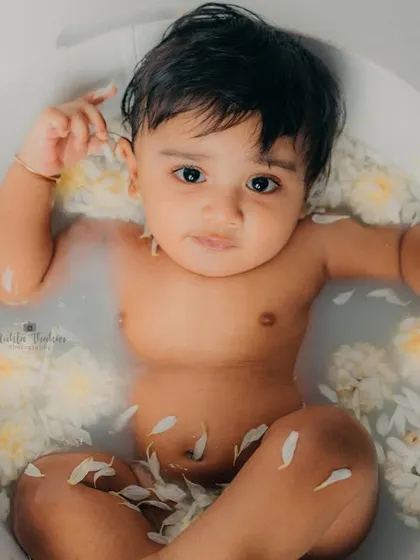 A calm moment in the tub. The flower petals floating in the water add a beautiful, gentle touch to the photo.
