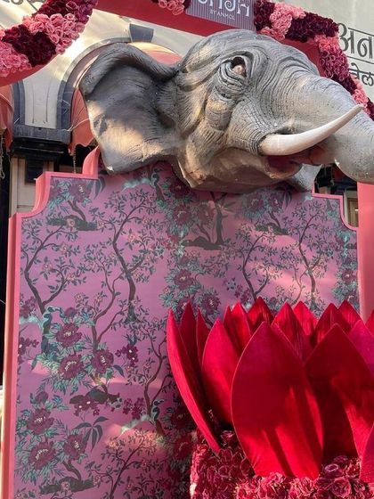 A side view of the elephant entrance, showing the depth and dimension of the sculpture. The custom-printed floral backdrop adds another layer of texture and elegance to the design.