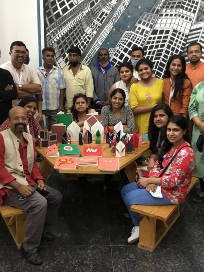 A group of participants proudly display the notebooks they created in a workshop focused on reusing paper waste. This is a perfect example of creative upcycling.
