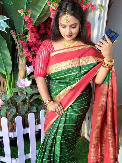 A beautiful silk saree draping with an open pallu. The red and green combination is classic, and the drape is perfect for a festive occasion.