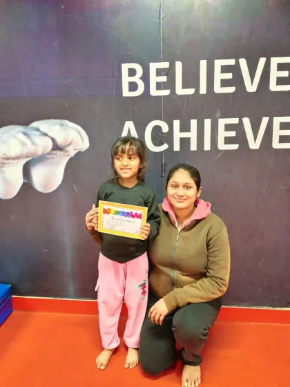 A happy student holds her "Awesomeness" certificate, celebrating her progress.