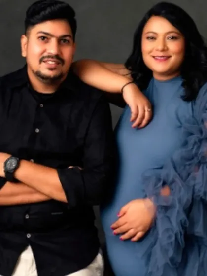 A stylish and modern couple's portrait, with the mom-to-be in our sophisticated blue high-neck gown.