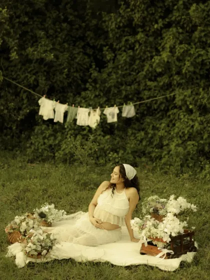 Relaxing in a beautifully styled outdoor setting. This shot captures a candid moment from the picnic-themed session, showcasing the thoughtful details like the flower baskets and vintage chest.