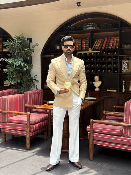 This beige double-breasted suit, paired with white trousers, creates a fresh and sophisticated ensemble.