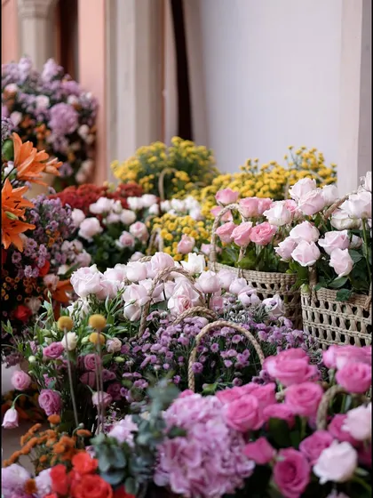 A flower market-style display with baskets filled with fresh pink, yellow, and purple blooms, adding a touch of rustic charm to the elegant brunch setting.