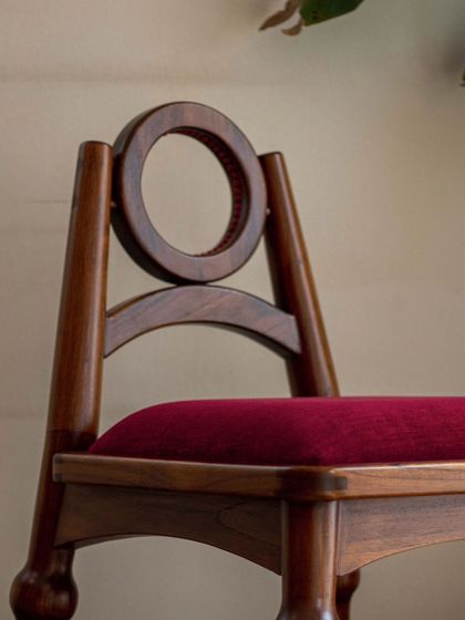 A series of images detailing the Manjadi chair, from its hand-turned legs inspired by the seed pod to the vibrant red upholstery. These shots highlight the craftsmanship and the deep cultural narrative behind this unique design.