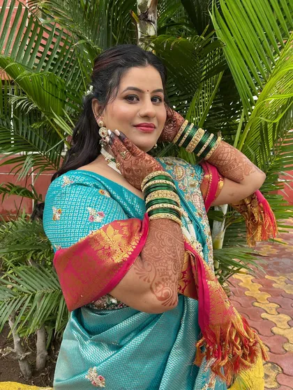 A vibrant engagement look for this bride in a beautiful turquoise saree. The makeup features a pop of color on the lips.