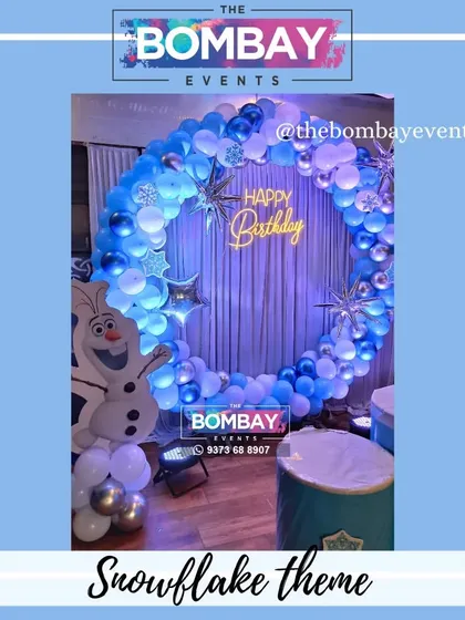 A detailed shot of the Snowflake and Frozen theme, focusing on the circular balloon arch with silver starburst accents. The cool blue and white colors create a perfect wintery feel.