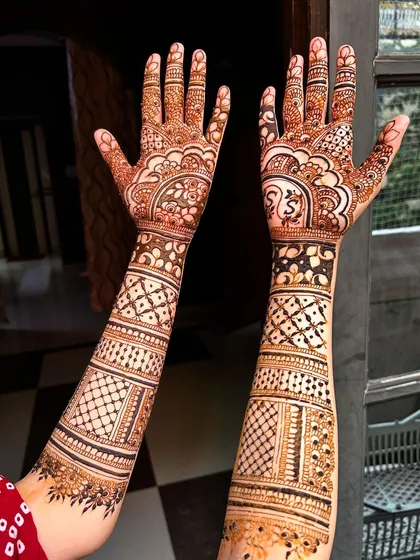 A minimal bridal design that is both modern and elegant. The pattern is less dense, focusing on clean lines and spaced-out motifs, including a personalized initial on the palm.
