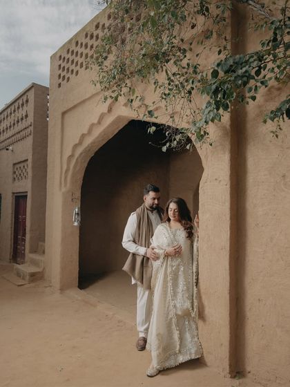 An intimate embrace in the alleyway of a Punjabi village. The natural light and rustic architecture provide a warm and authentic setting for this romantic couple portrait.