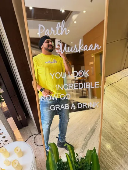 A fun mirror selfie at a wedding reception. The sign says it all: "You look incredible. Now go grab a drink." That's the spirit.